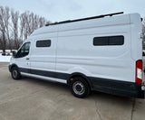White camper van with a roof rack and custom windows, perfect for an RV rental adventure.
