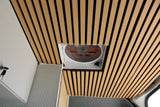 Overhead view of an RV rental interior: slatted wooden ceiling, central vent fan, and white wall with keys.