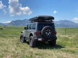 Gray Jeep Wrangler with iKamper rooftop tent, an ideal setup for an RV rental experience in the scenic mountains.