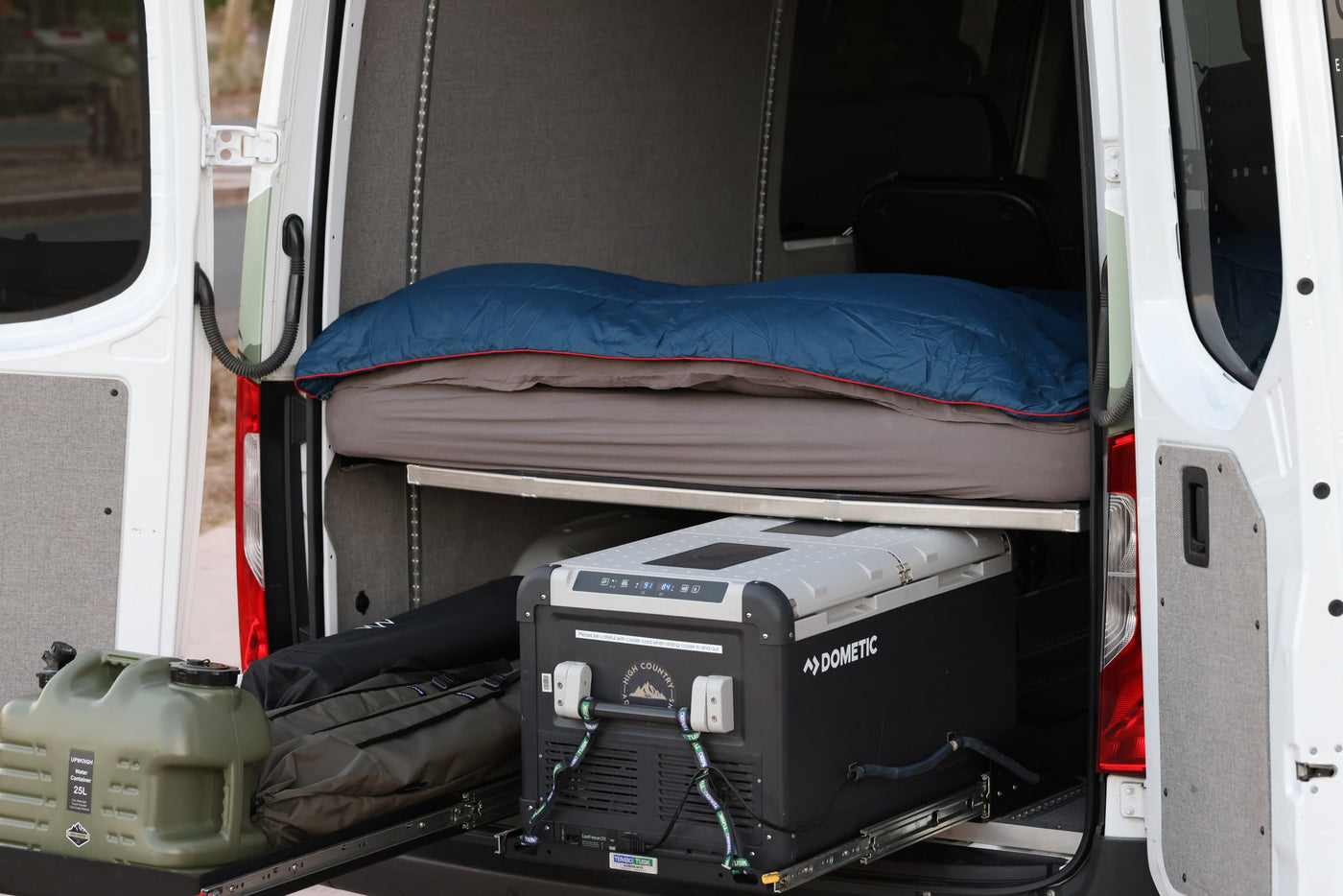 This RV rental's rear setup offers a comfortable bed, Dometic cooler, and water storage for off-grid adventures. — photo 5