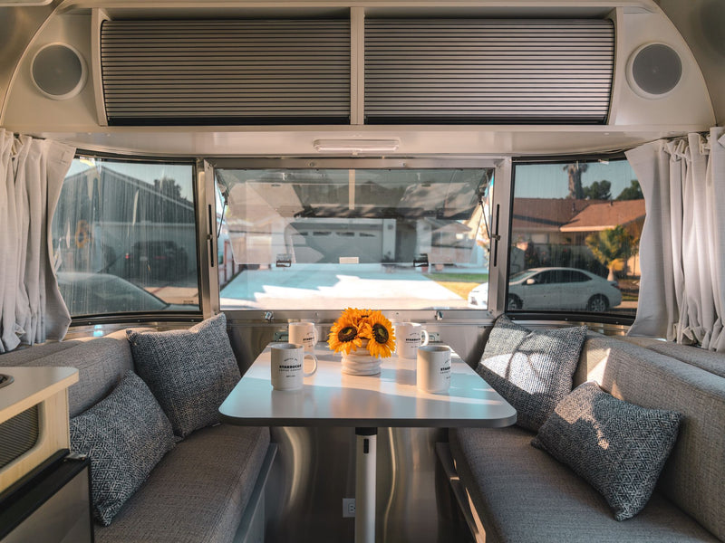  with a white shower curtain visible.|RV rental interior: Comfortable seating — photo 15