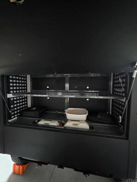 Ample storage in this RV rental's organized rear compartment, featuring shelves & bins for adventure essentials.