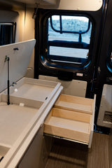 Inside this RV rental, discover smart storage with opened drawers and a pop-up compartment, perfect for your road trip essentials.
