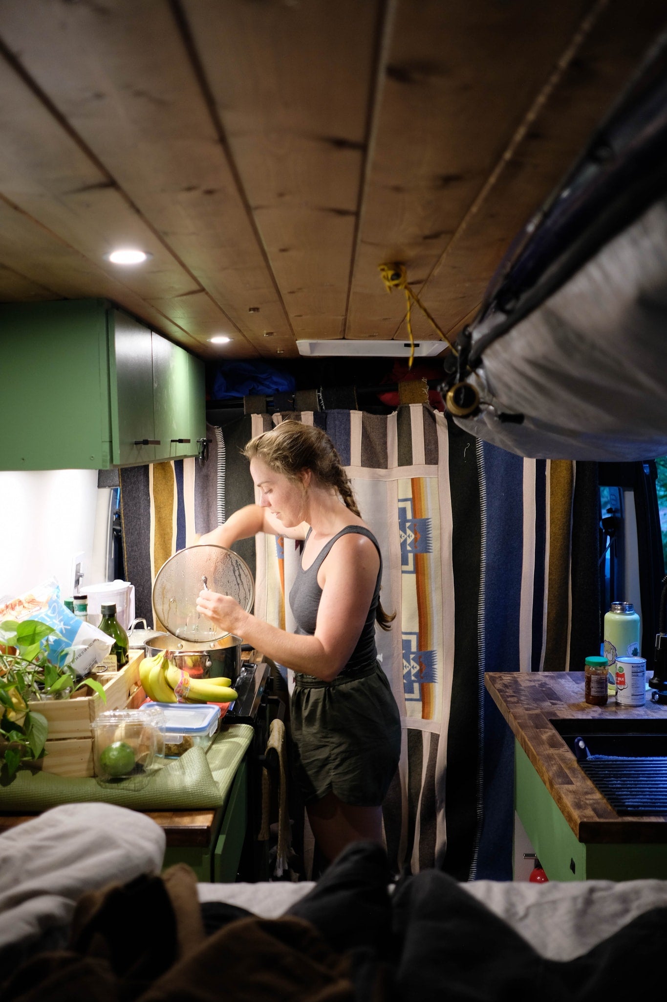 Woman cooks in her RV rental kitchen, showcasing the compact yet functional setup for meals on the go inside a camper van. — photo 7
