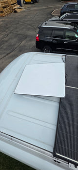 Top-down view of an rv rental roof: Starlink antenna and solar panels for mobile internet & power.