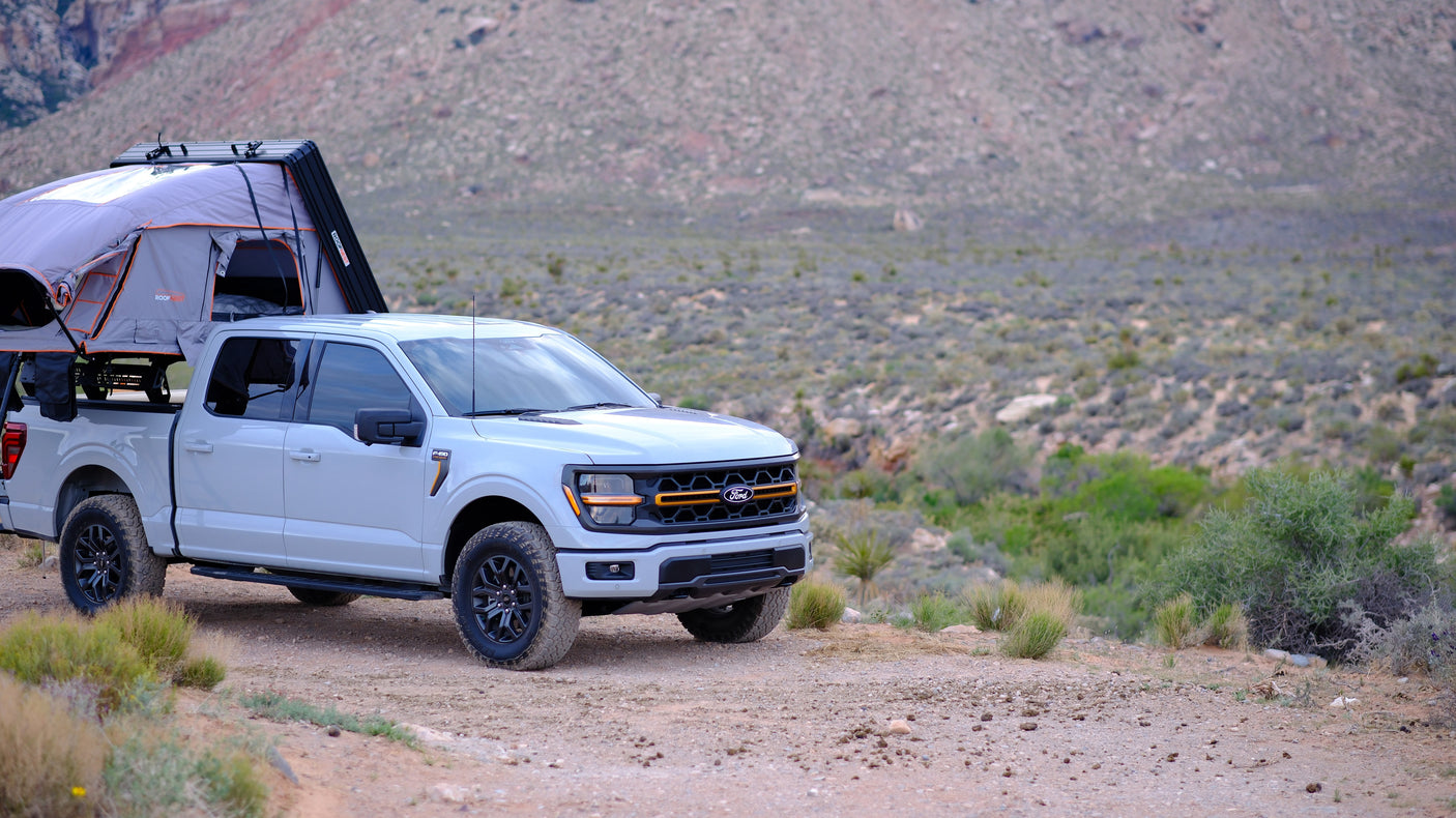 Adventure-ready Ford F-150 with a rooftop tent, a great RV rental alternative for desert off-road camping.