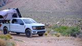 Adventure-ready Ford F-150 with a rooftop tent, a great RV rental alternative for desert off-road camping.