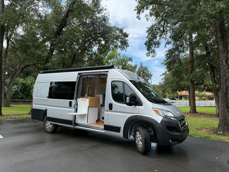 Stylish silver rv rental camper van with an open side door — photo 1