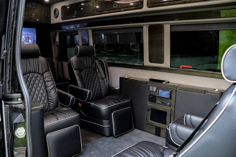 Step inside this luxury rv rental, featuring plush black leather captain's chairs and an entertainment system for comfortable travel.