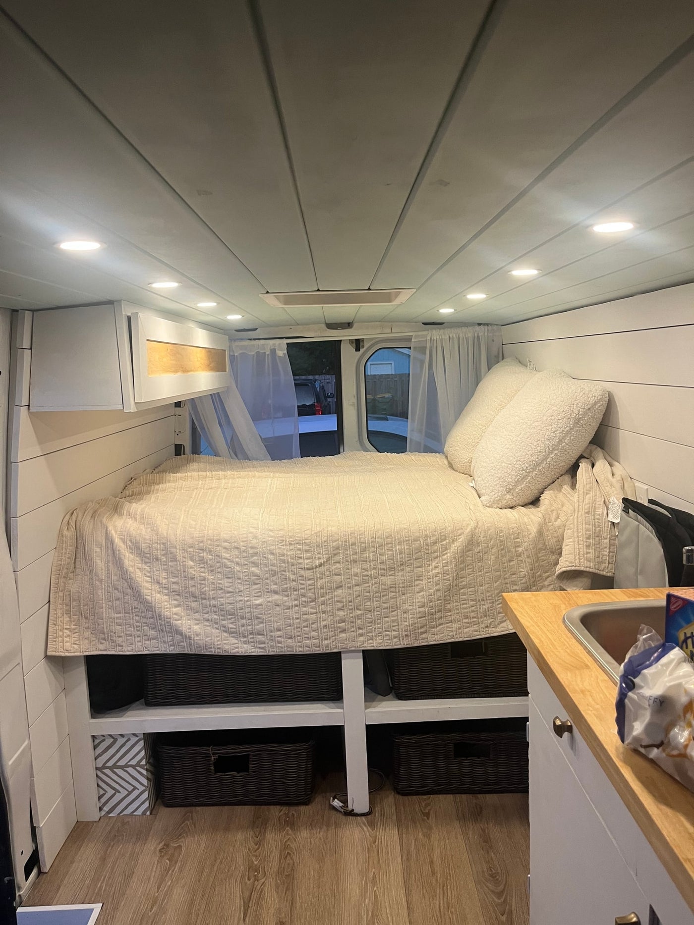 Experience van life in this cozy rv rental! Features a comfortable bed, kitchen area, and organized storage inside. — photo 7