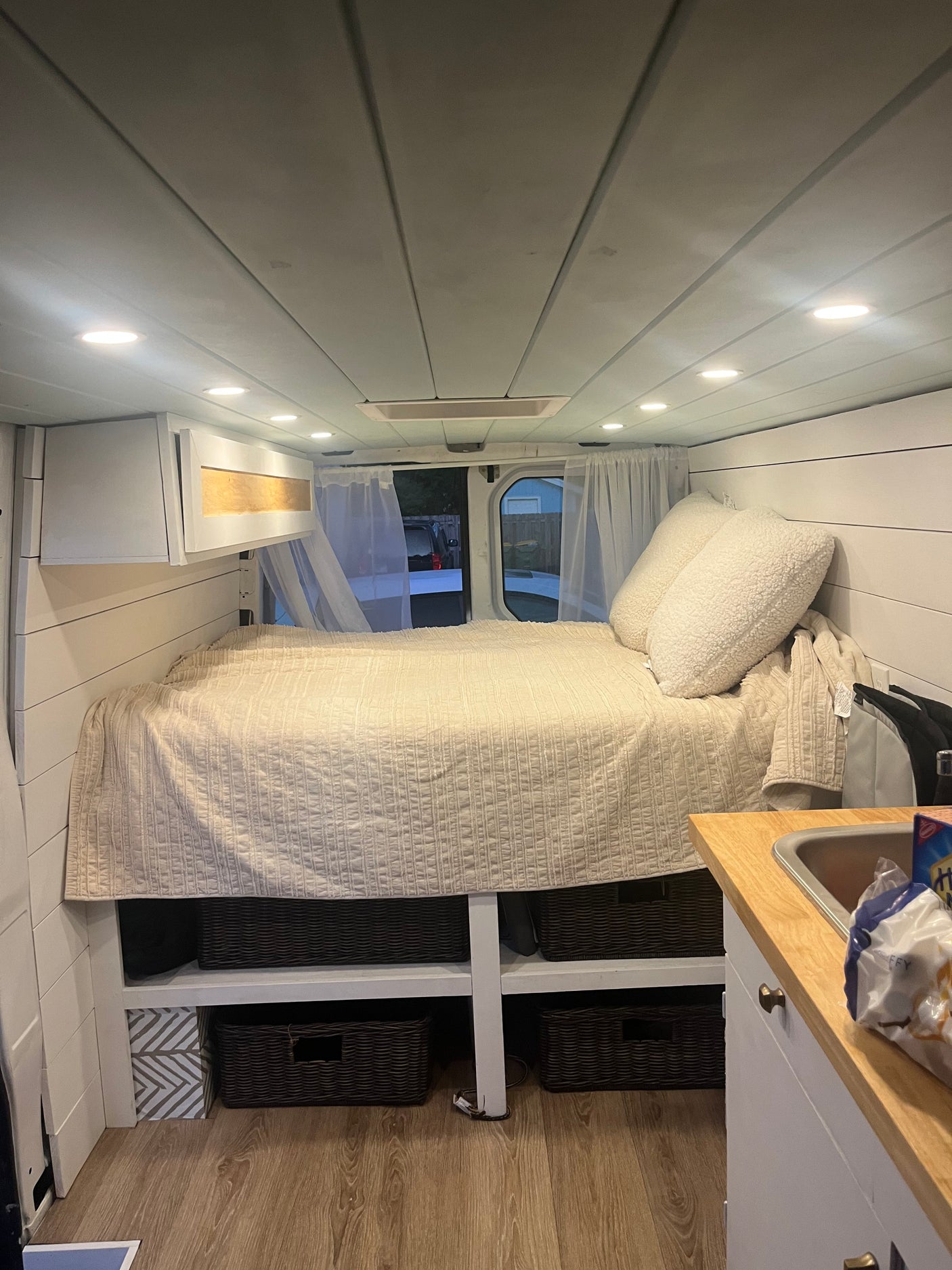 Experience van life in this cozy rv rental! Features a comfortable bed, kitchen area, and organized storage inside.