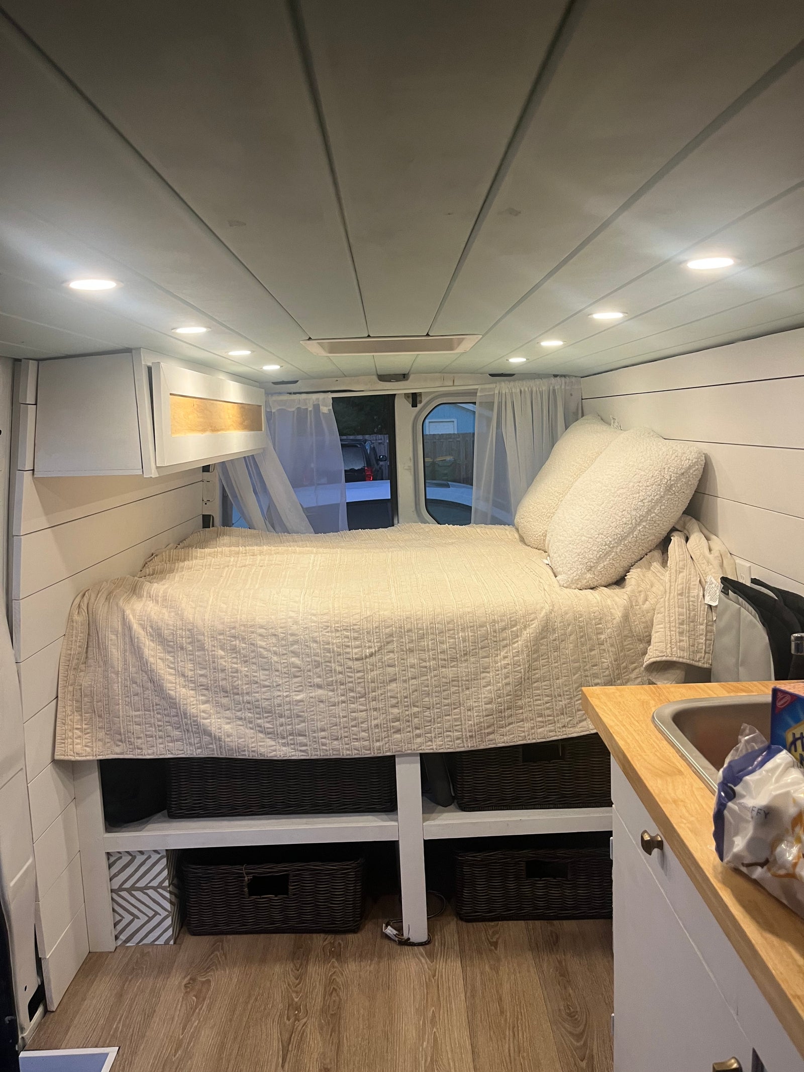 Experience van life in this cozy rv rental! Features a comfortable bed, kitchen area, and organized storage inside.