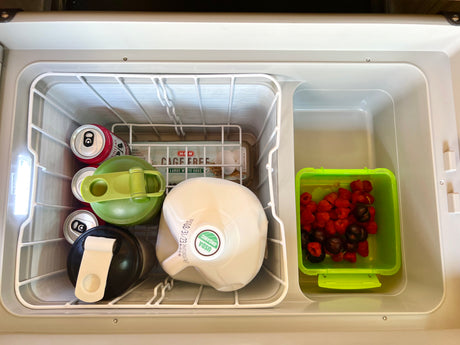 RV rental portable fridge stocked with drinks, organic milk, eggs, and fresh berries for a refreshing journey.