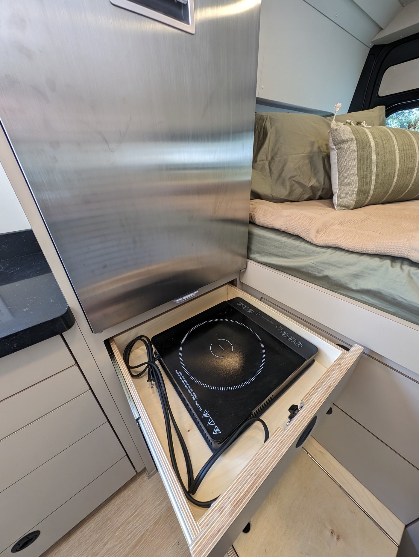  and smart design.|Cozy RV rental bed with a snowy view out the back doors. Ideal for winter getaways.|Modern RV rental interior: kitchen with sink — photo 12