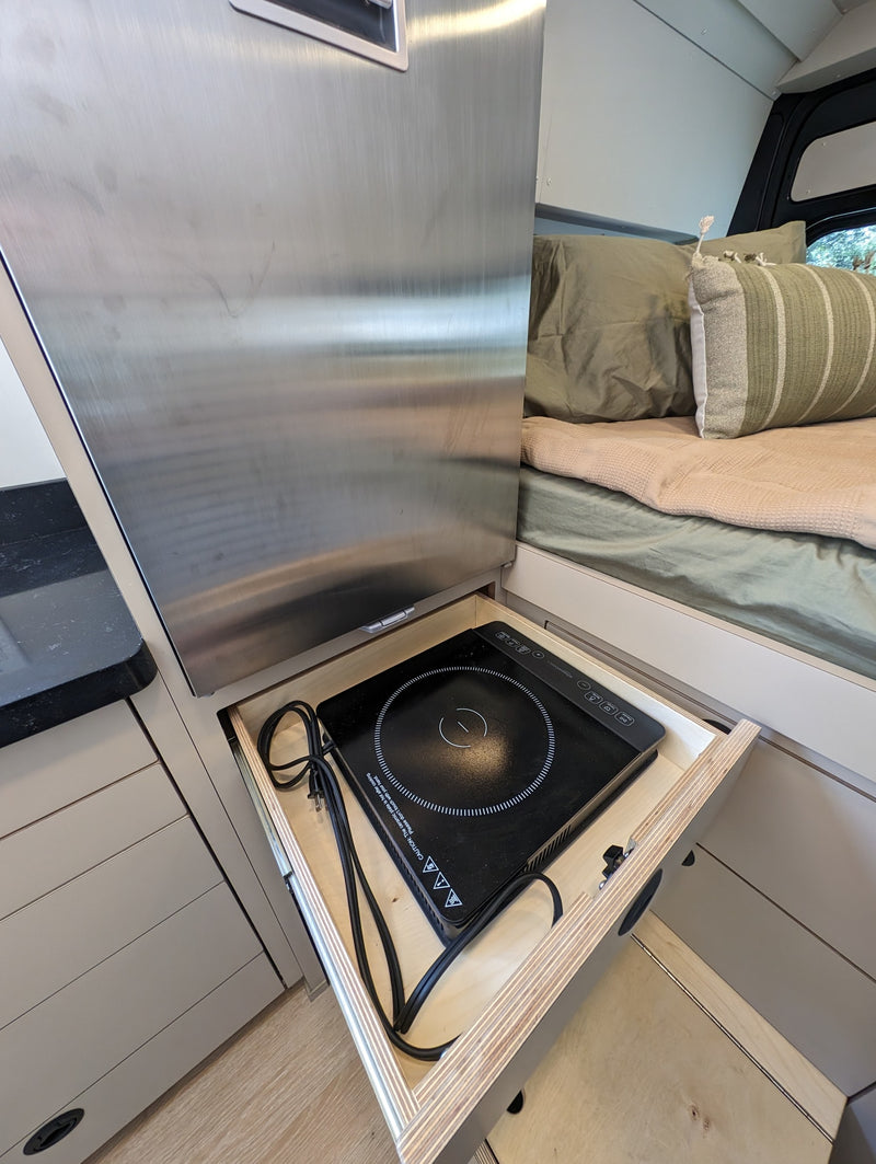  and smart design.|Cozy RV rental bed with a snowy view out the back doors. Ideal for winter getaways.|Modern RV rental interior: kitchen with sink — photo 12