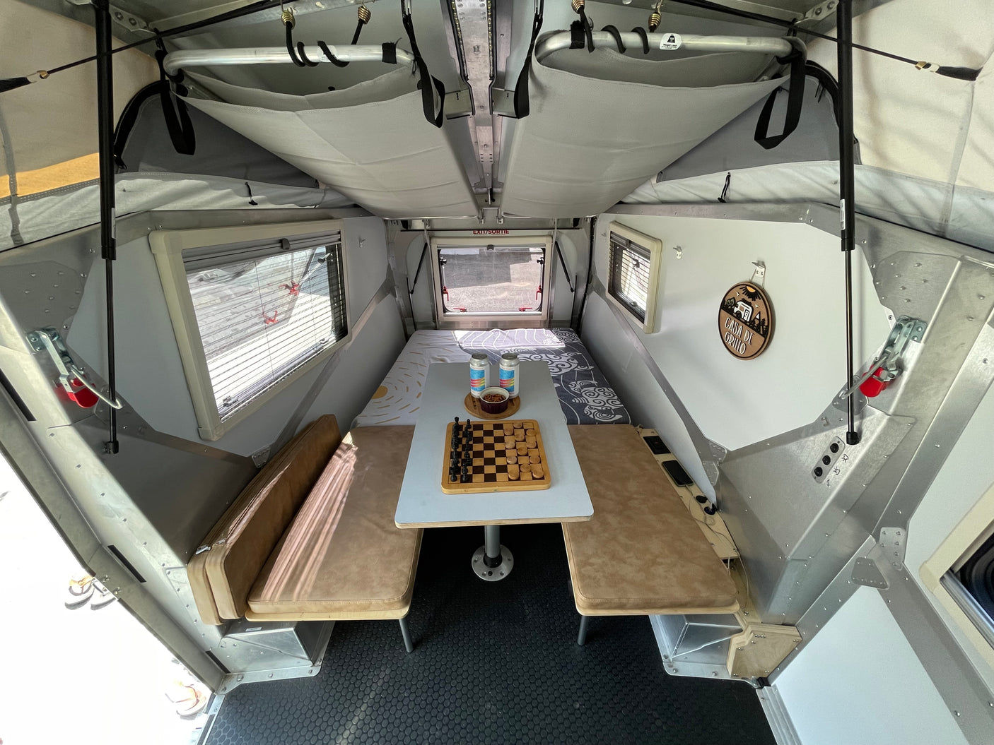 Cozy pop-up RV rental interior, featuring a flexible dining/sleeping area and clever storage. Ready for adventure.