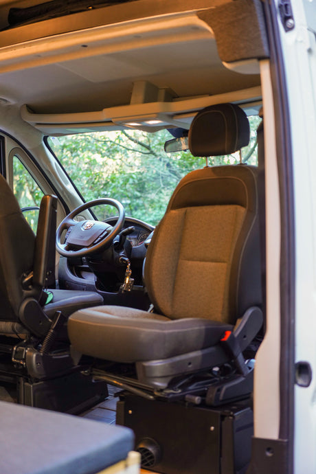 Inside this RV rental: front cabin driving area with comfortable seats, ready for adventure and scenic travel.