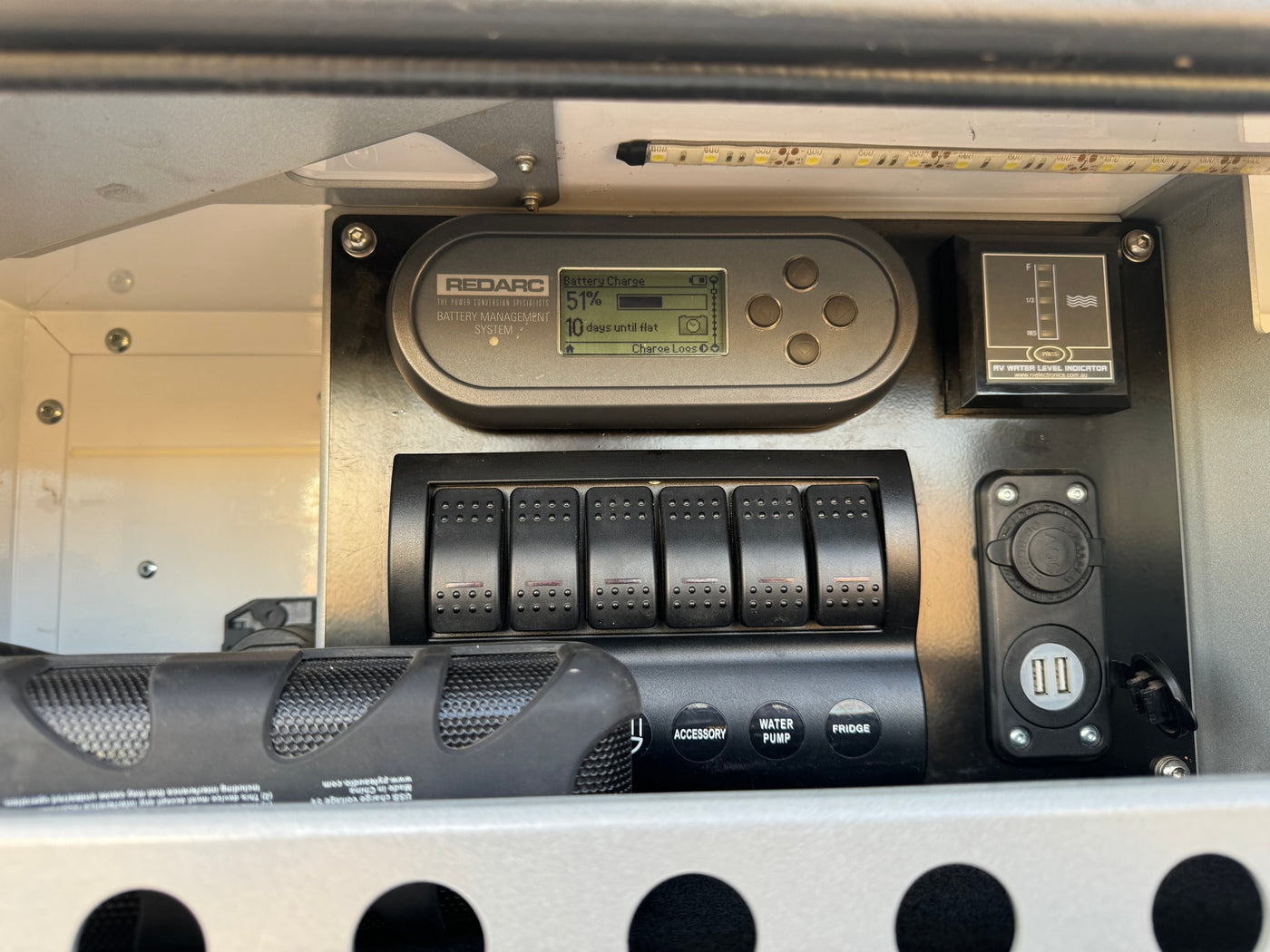 RV rental control panel: Redarc battery monitor (51%), water level, switches for fridge/pump, and USB power outlets. — photo 6