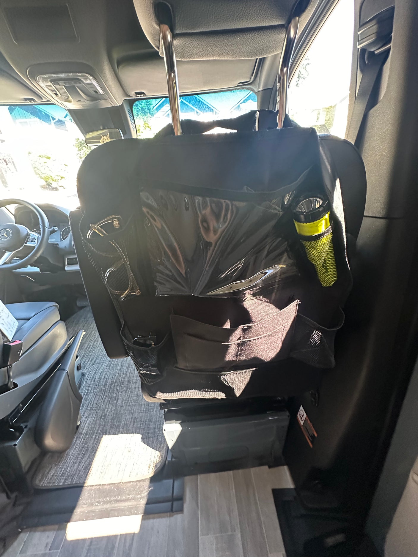 RV rental interior showing a functional seatback organizer on a front seat, great for storing travel essentials like sunglasses and a flashlight.
