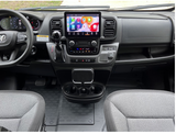 RV rental van interior. Modern dashboard with large touchscreen infotainment, digital cluster, and practical controls. Front seats visible.