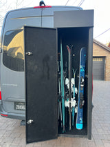 RV rental Sprinter van: custom rear ski storage open, revealing multiple skis and poles for winter sports trips.