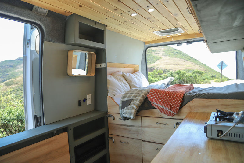  & clever storage for mobile living.|RV rental parked with open rear doors showing bed & storage — photo 4