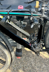 A dirty mountain bike with knobby tires is securely mounted on a Yakima bike rack, ready for an RV rental outdoor adventure.