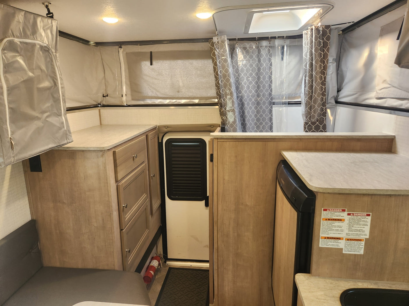 Compact interior of an rv rental features a kitchen, shower, and convertible sleeping areas.