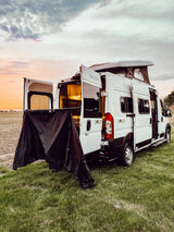 Experience adventure with this Winnebago Solis RV rental at sunset, doors open with privacy screen. Perfect for camping.
