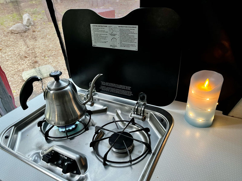  with cooking instructions on the open cover and a cozy LED candle nearby.|Inside a comfortable rv rental: Kitchenette — photo 6