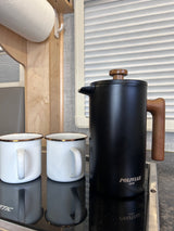 RV rental kitchen essentials: POLIVIAR French press, two enamel mugs, and paper towels, ready for camping.