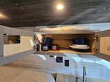 RV rental: Organized kitchen cabinet with Denali mugs & cookware. Sink and controls visible.