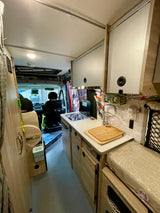 Explore this compact and functional kitchenette inside an RV rental, featuring a stove, sink, and ample storage for on-the-go living.