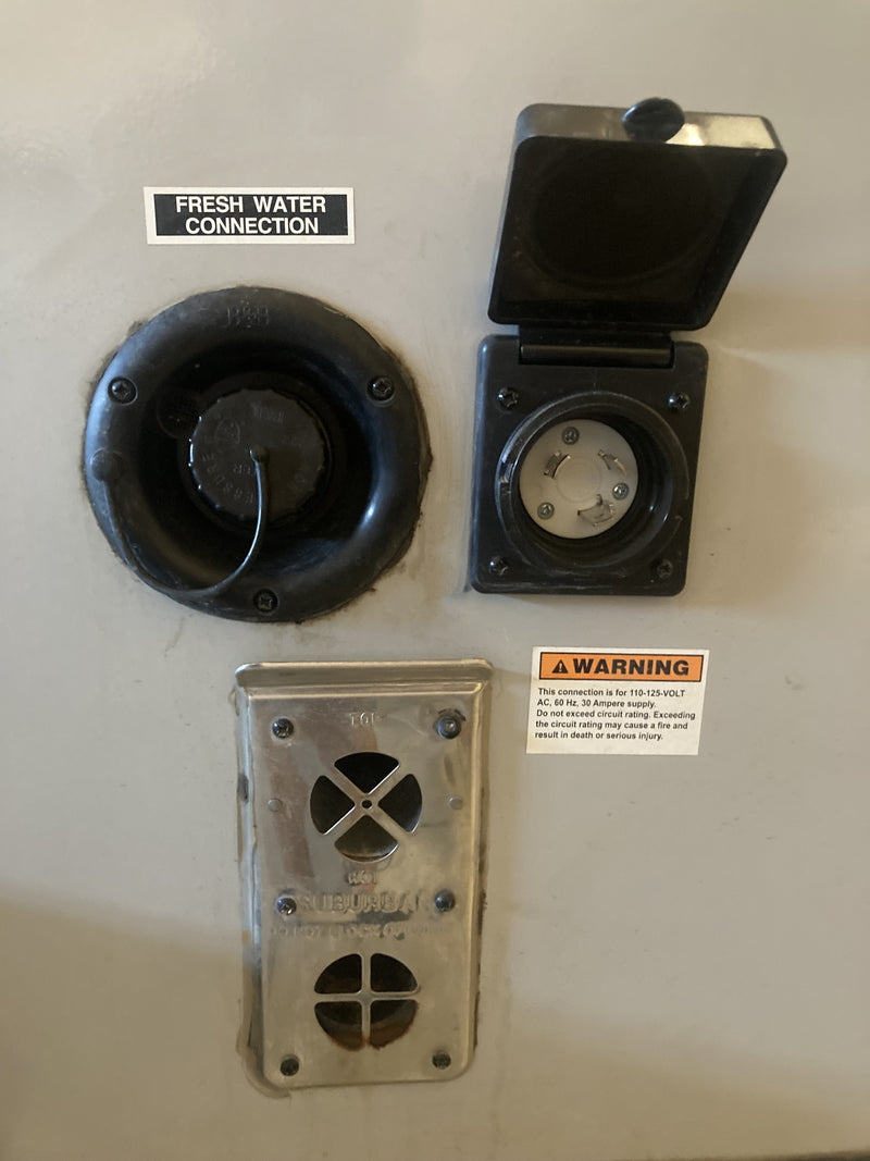 Essential RV rental exterior connections: fresh water inlet, 30A power hookup, and water heater vent. — photo 18