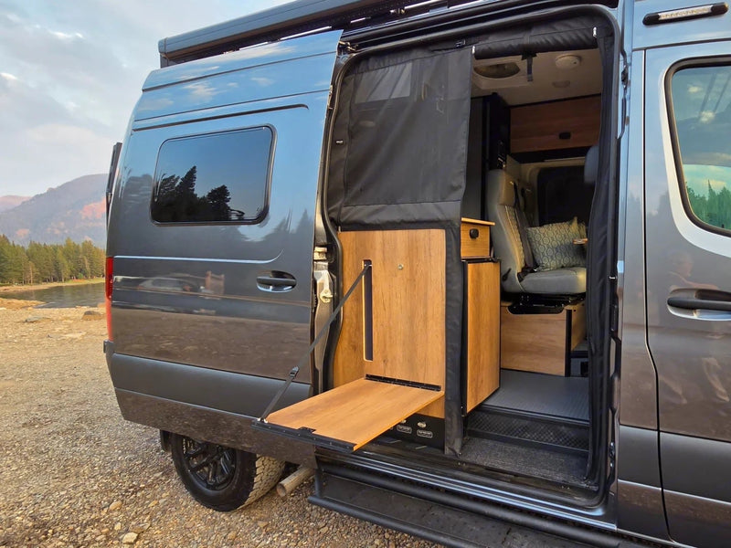  revealing a cozy bed & gear. #vanlife #adventure|This rv rental showcases an open camper van side door with a fold-down table and cozy interior — photo 7