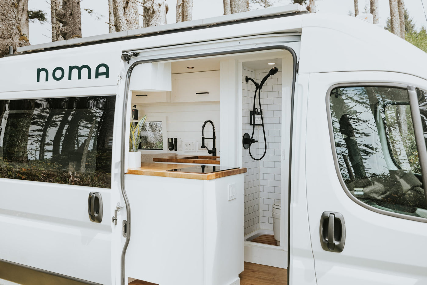 Inside a pristine white rv rental, revealing a stylish camper van interior with a kitchen and shower. — photo 2