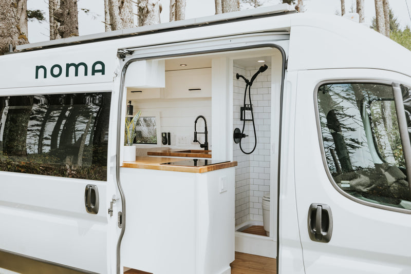 Inside a pristine white rv rental, revealing a stylish camper van interior with a kitchen and shower. — photo 2