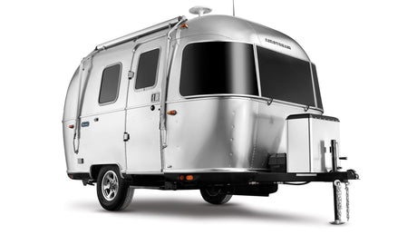 A sleek silver Airstream travel trailer, an ideal RV rental, showcasing its iconic rounded design and large black windows.