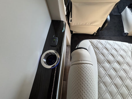 Luxury RV rental interior with comfortable seating, illuminated cup holder, and convenient USB charging port for travel comfort.
