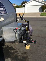 RV rental travel trailer's hitch area, featuring a diamond-plate storage box, spade, and JACK-IT bike rack for camping.