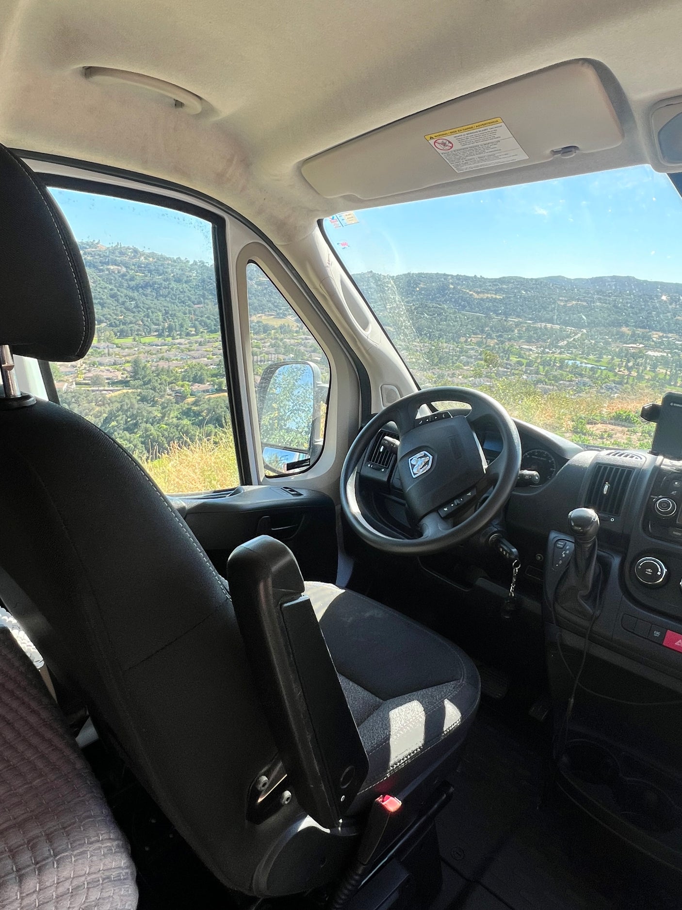 RV rental: Driver's view from inside the van, showcasing the dashboard and a beautiful mountainous landscape outside.