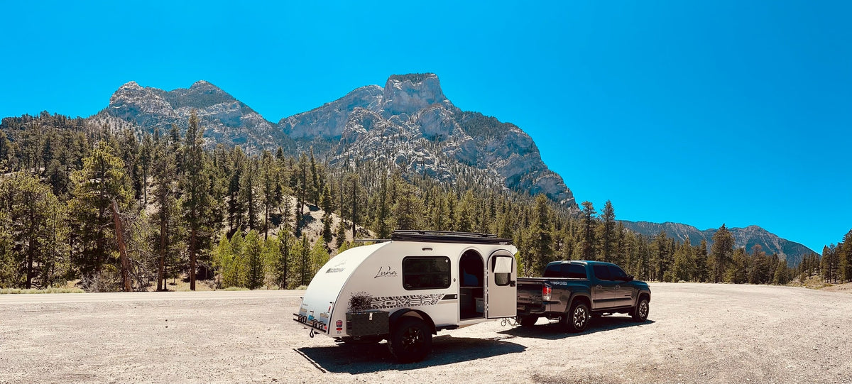 A Tacoma truck tows a compact teardrop RV rental