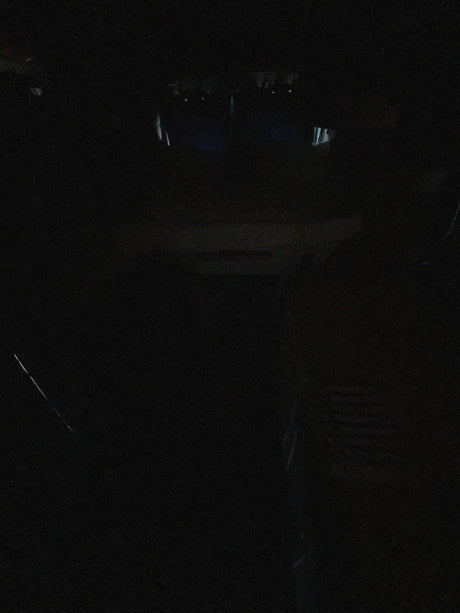 Extremely dark RV rental interior at night, with only faint outlines of the cabin visible.