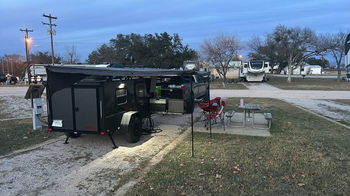 Dusk at an RV park, showcasing an InTech camper trailer, pickup truck, and picnic setup. Ideal for an rv rental outdoor adventure. — photo 5