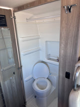 RV rental compact wet bath: toilet, shower area, and mirrored door. Essential for life on the road.