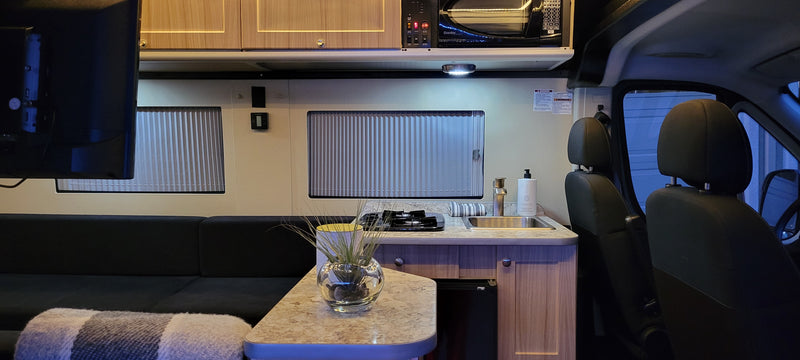Experience this RV rental's cozy interior: fully equipped kitchenette, sofa, and front cabin area. — photo 15