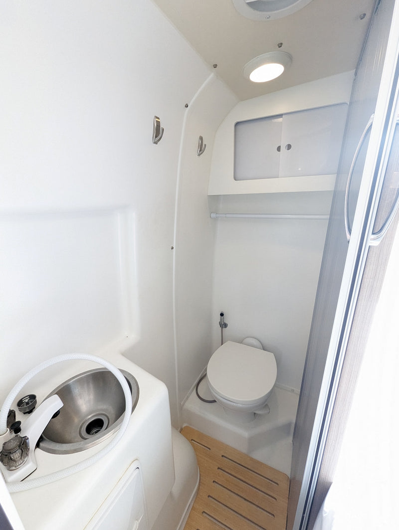  and compact bathroom.|Comfortable RV rental interior showcasing beige seating — photo 7