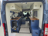 View inside a spacious rv rental camper van, showing its modern kitchen, bed area, and organized storage for travel.