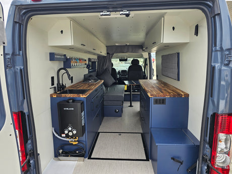 View inside a spacious rv rental camper van, showing its modern kitchen, bed area, and organized storage for travel.