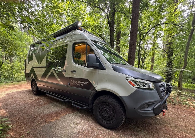 Adventure-ready Nowhere Vans RV rental in the forest. This custom light grey camper van is perfect for van life camping.|A custom Sprinter camper van — photo 1